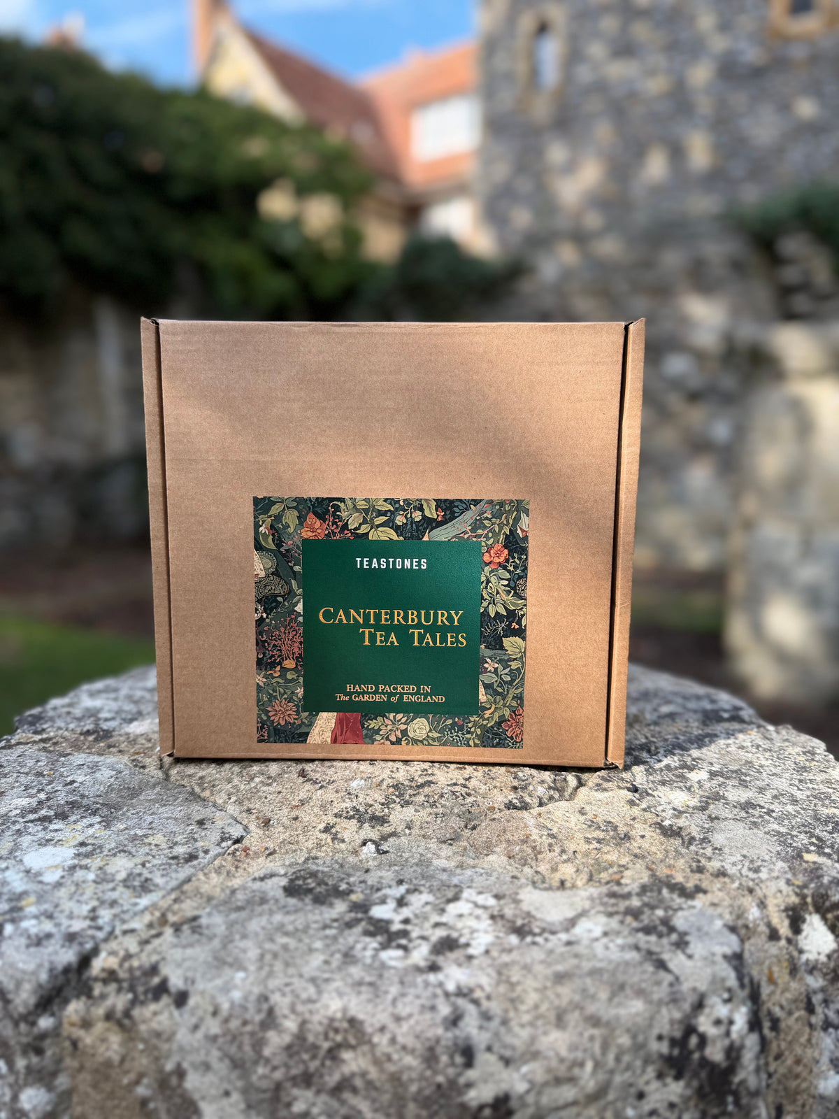 Canterbury Tea Tales Orchard Collection box and tea pouch beside historic Canterbury architecture